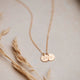 Gold stamped jewelry attached to a gold initial necklace by Hello Adorn.