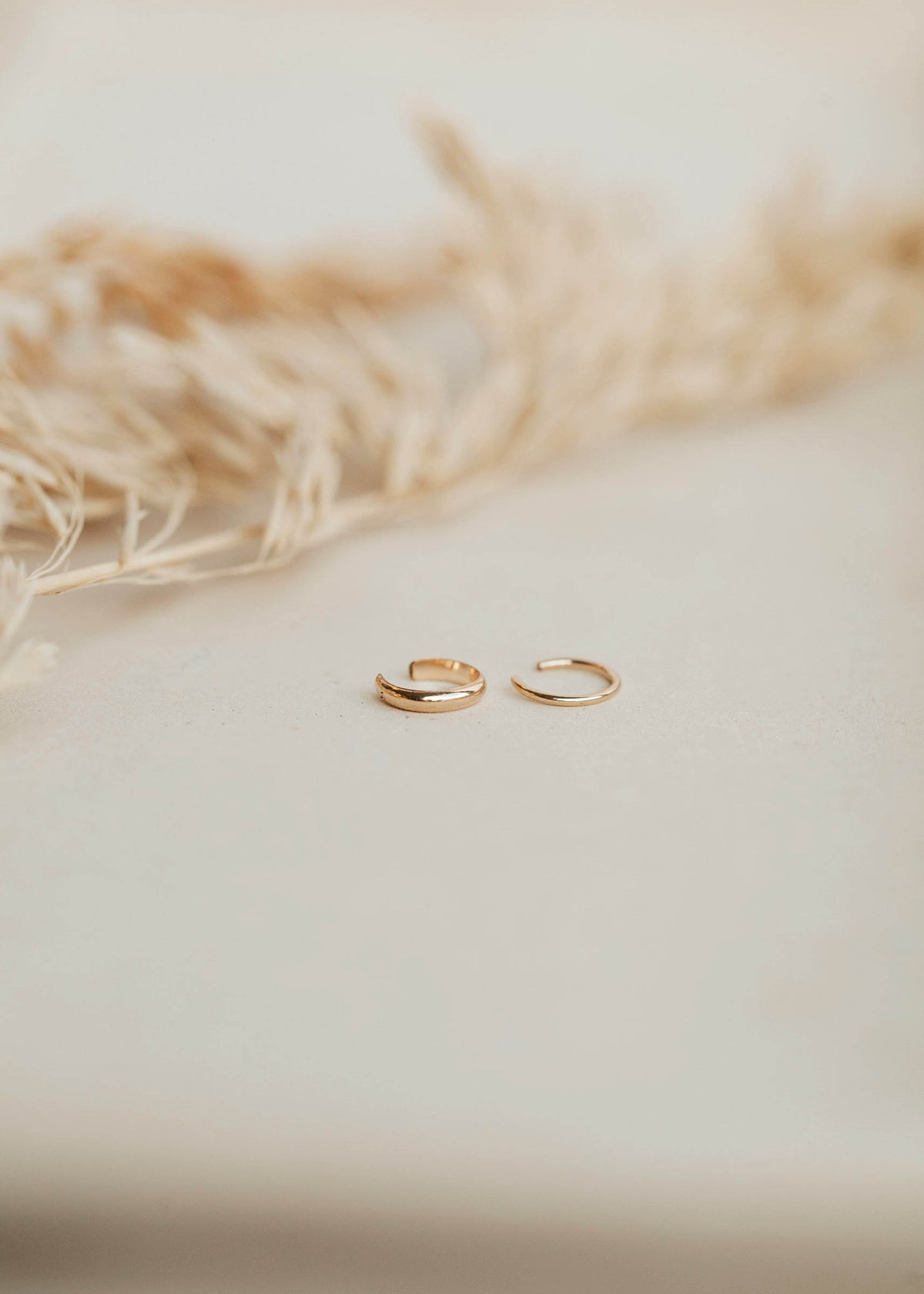 A thick ear cuff and a thin ear cuff sold as a pair in the Ear Cuff Duo by Hello Adorn which features a pair of ear cuffs as without piercing earrings.