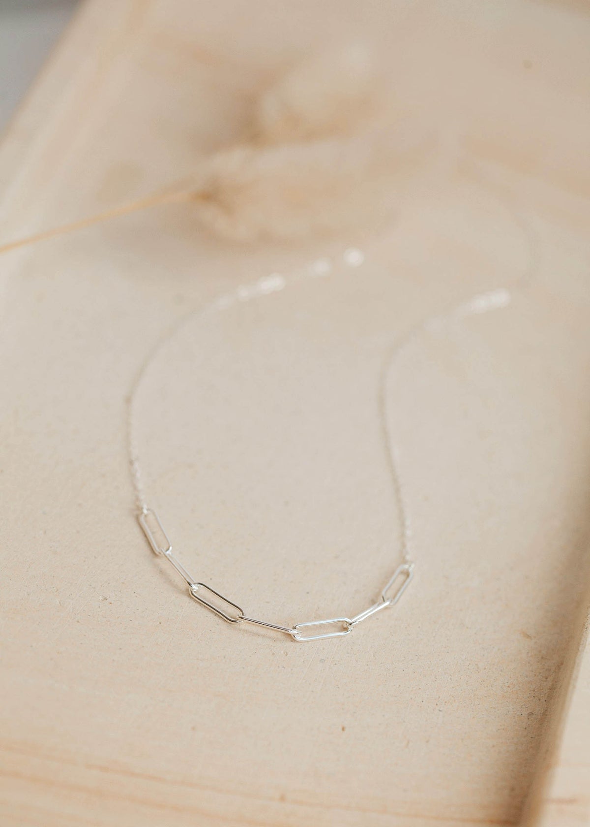A sterling silver statement necklace created by Hello Adorn, this paperclip necklace is attached to a chain necklace to create this customizable linked chain necklace.