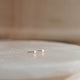 14k gold fill tiny dot studs by Hello Adorn laying flat.