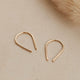 14k gold fill tiny horseshoe threader earrings by Hello Adorn on a beige surface with pampas grass