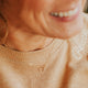 Model wearing a gold interlocking circle necklace by Hello Adorn.